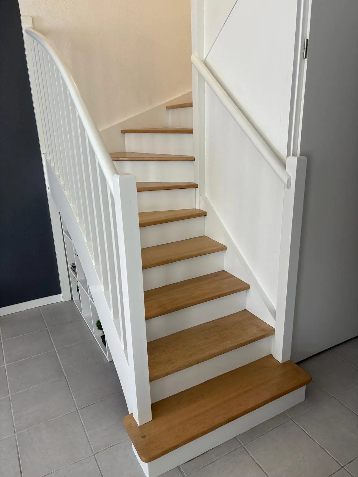 Le même escalier après travaux, rampe et contremarches peintes en blanc, marches en bois clair