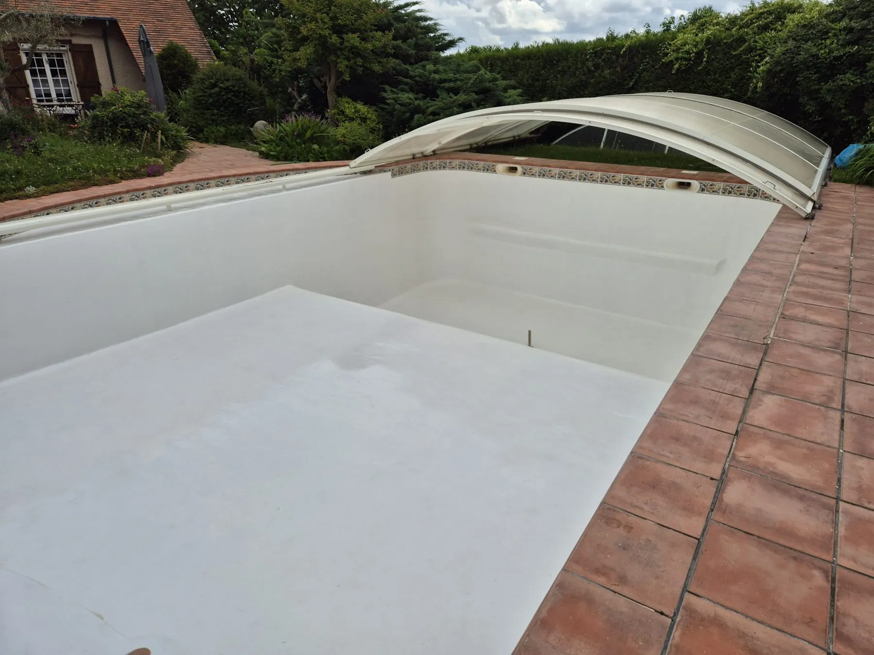Bassin de piscine après application du nouveau revêtement blanc