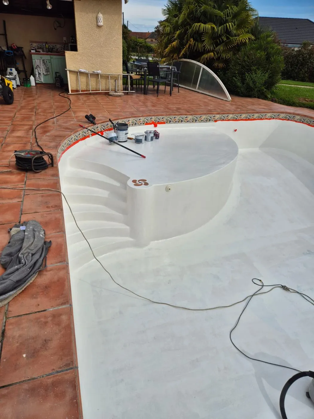 Marches d'un bassin de piscine pendant l'application du revêtement blanc