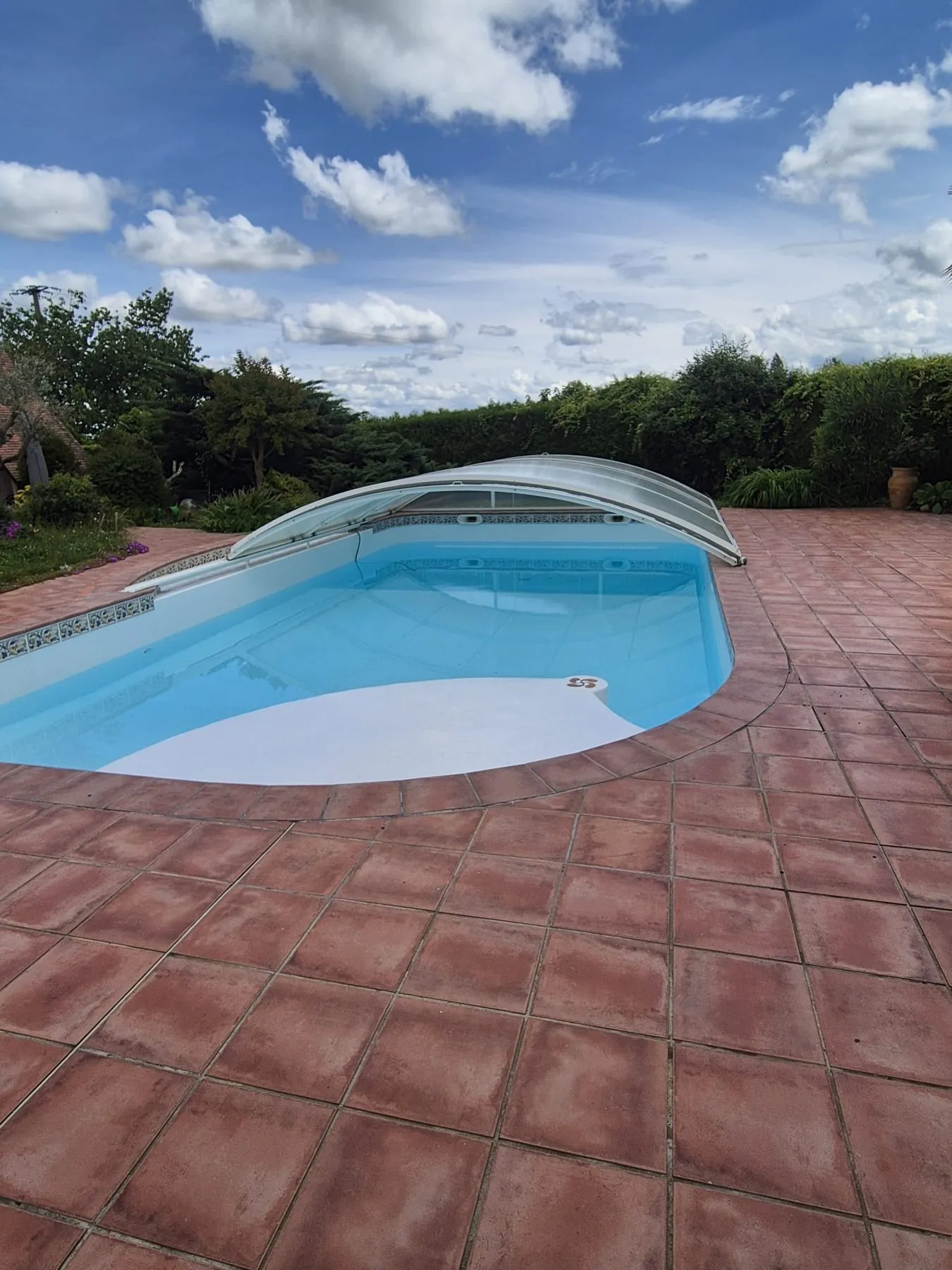 Piscine rénovée remise en eau, vue depuis la terrasse en terre cuite