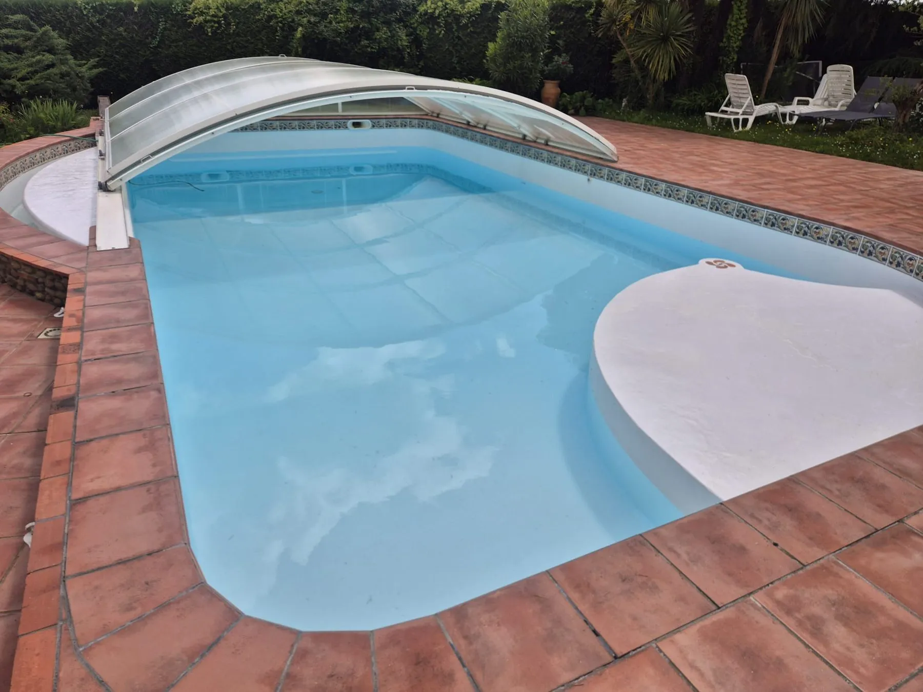 Piscine remise en eau après rénovation, entourée de dalles en terre cuite