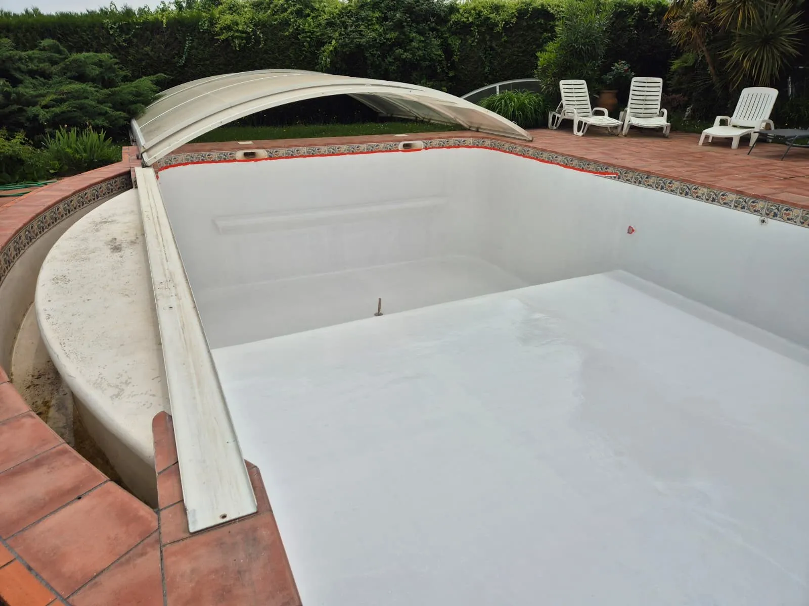 Bassin de piscine terminé avant sa remise en eau, avec ses marches d'angle