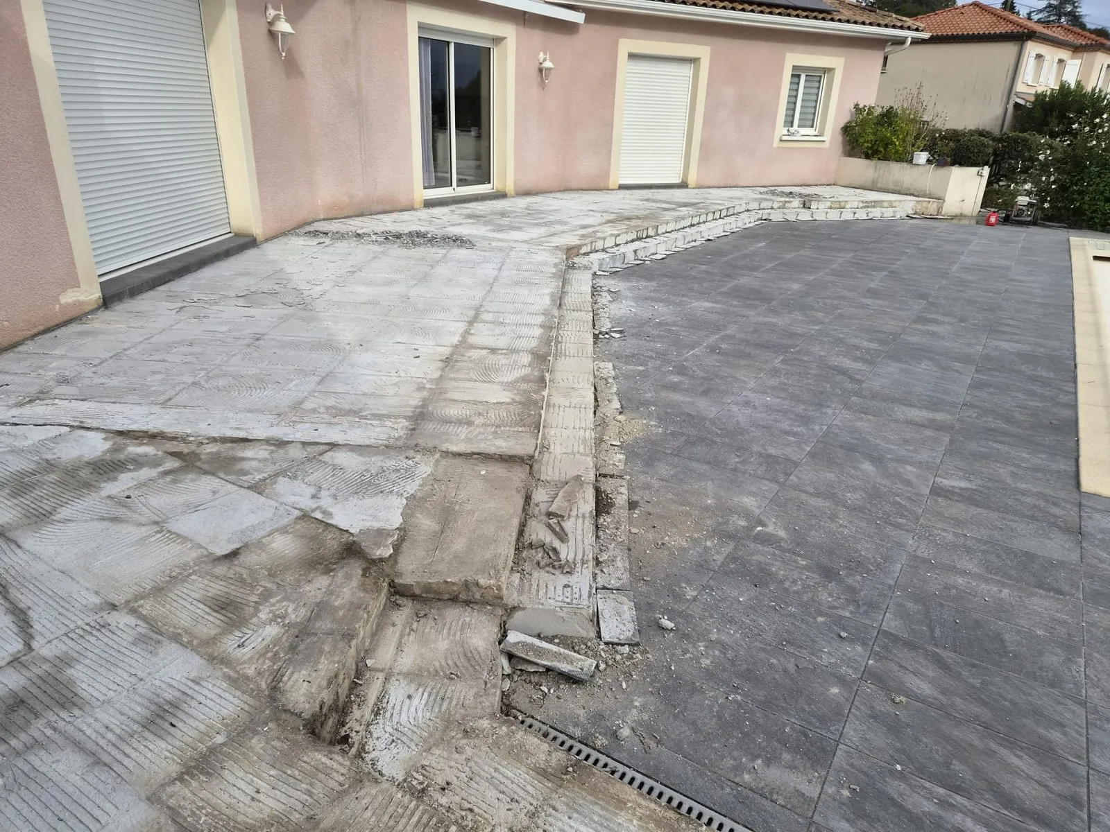 Terrasse devant une maison, nouveau carrelage gris à droite et support à nu à gauche